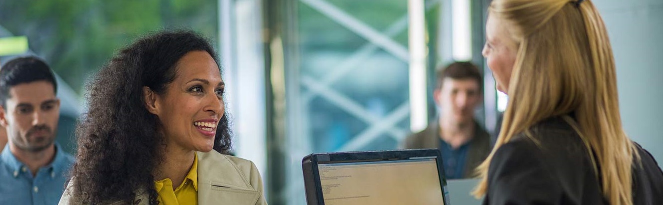 Smiling young woman conducting business at the bank counter.